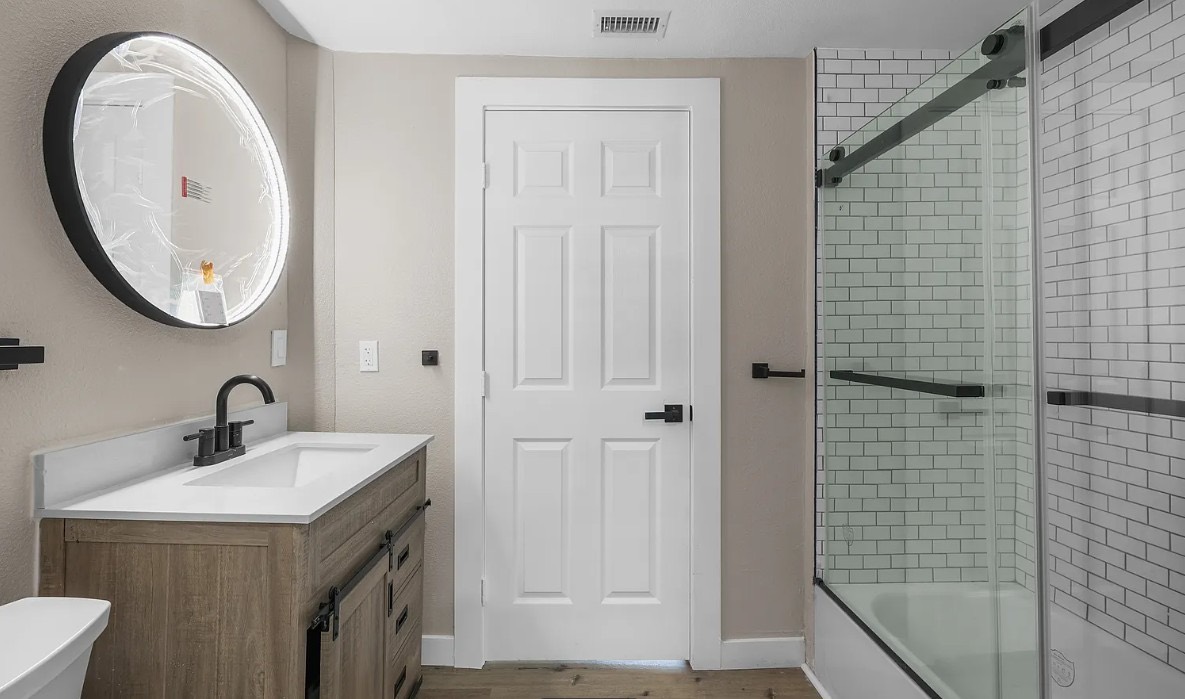 Wood vanity, subway tile, and matte black fixtures