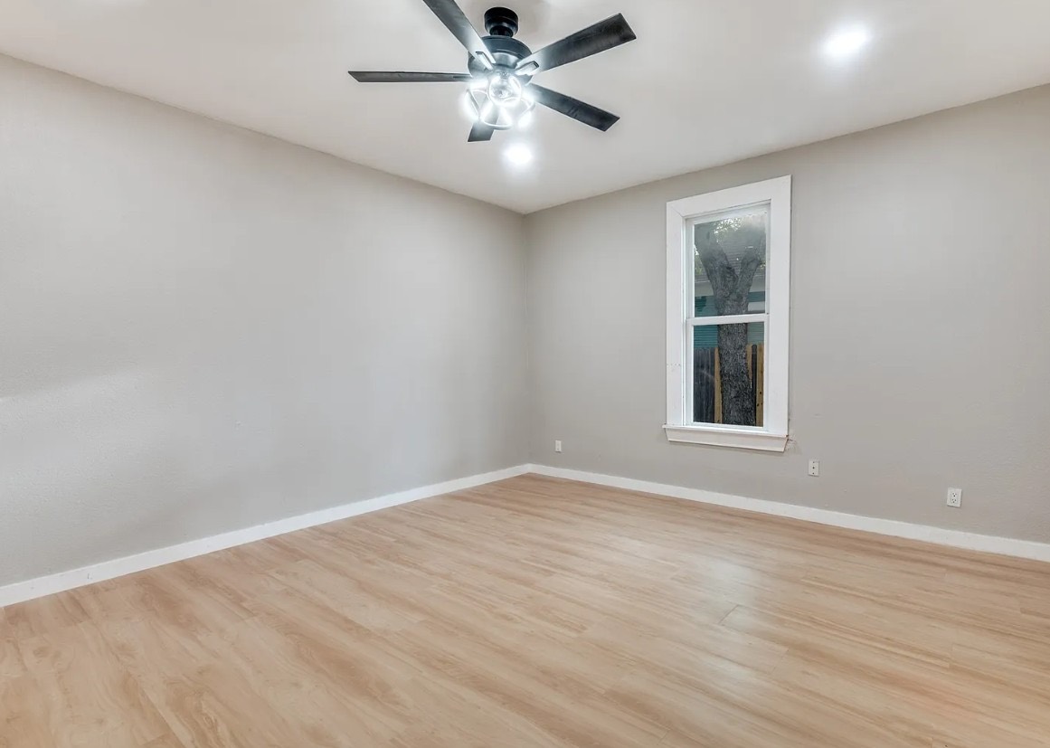 Bedroom with new flooring, trim, and ceiling fan
