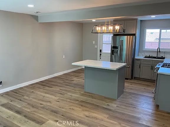 Gray cabinetry, quartz island, and stainless appliances
