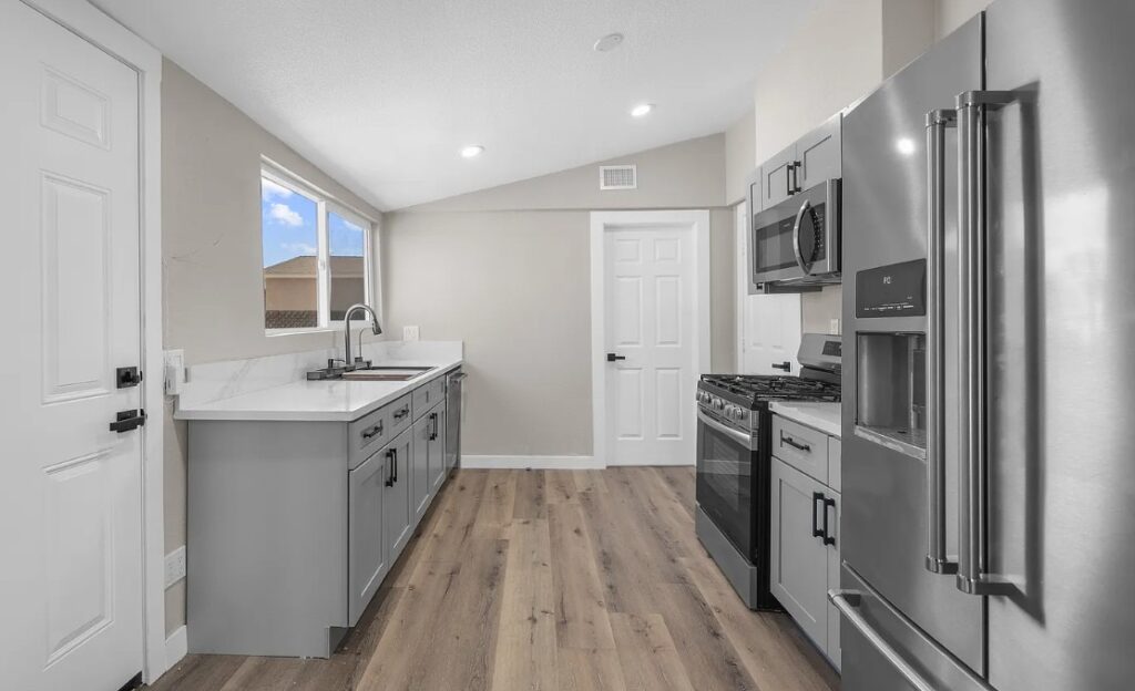 Galley kitchen remodel with gray cabinets and stainless appliances