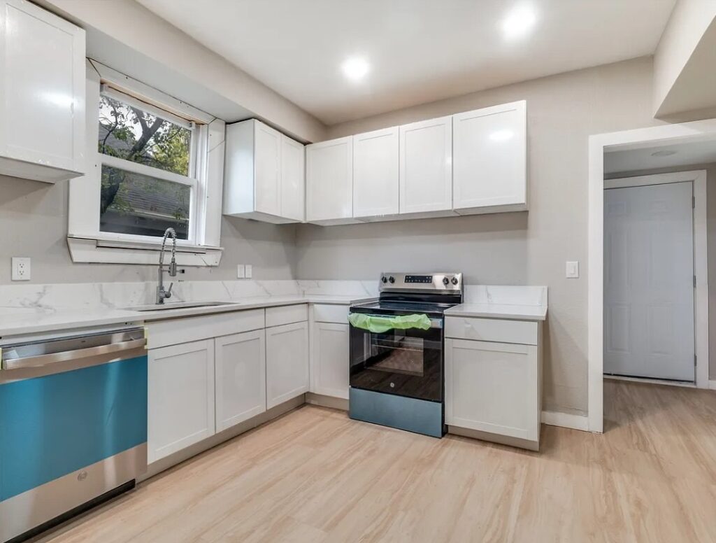 Kitchen remodel with white shaker cabinets and marble-look counters