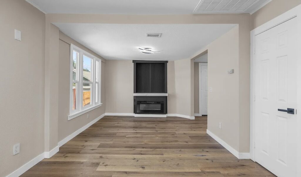 Living room renovation with new fireplace surround and wood-look flooring