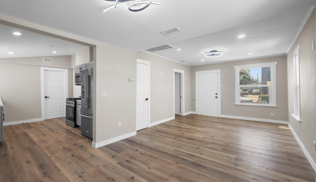 Open-plan living area and kitchen with new flooring and lighting